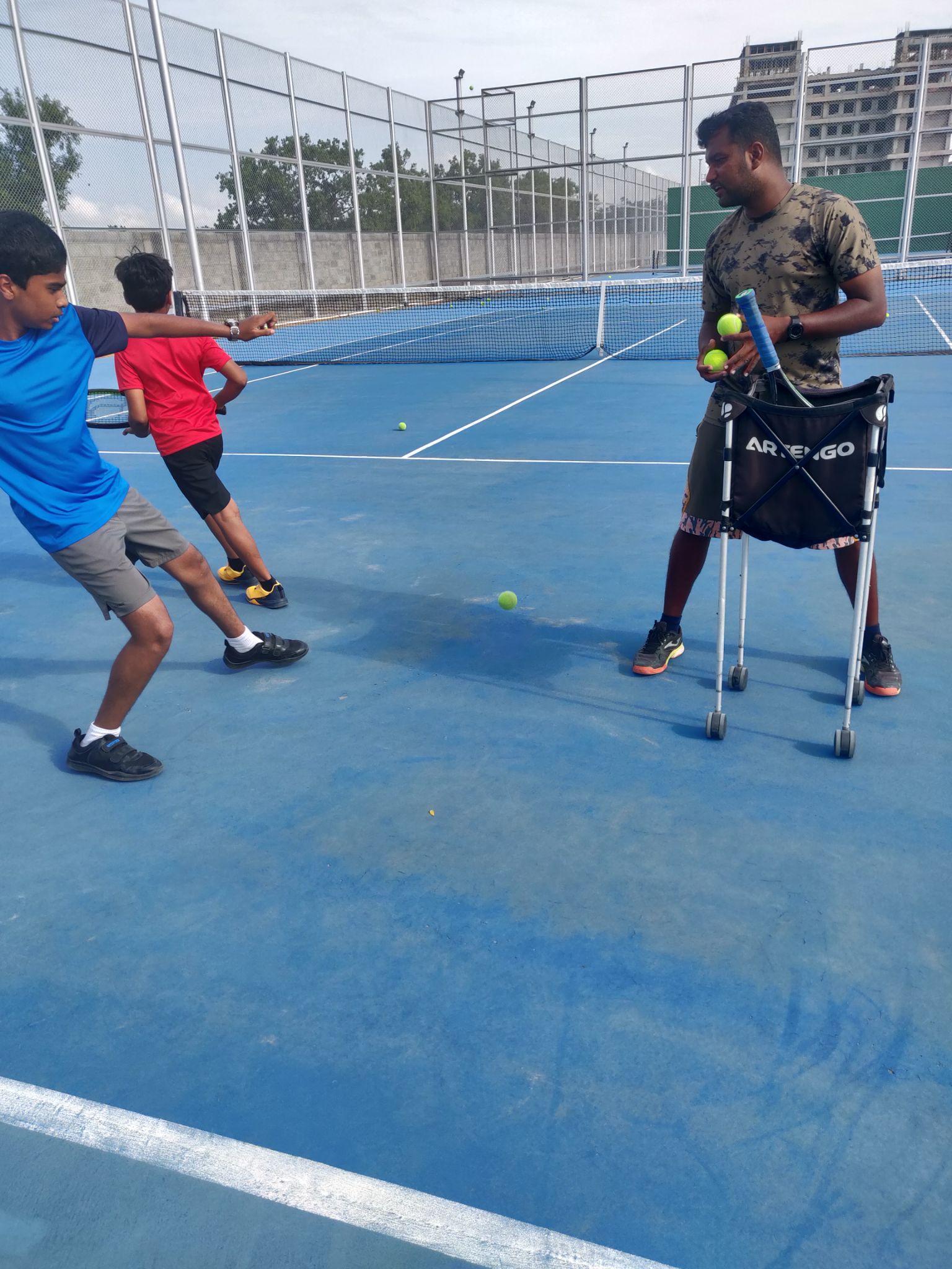 The problem: a coach feeding balls by hand while trying to watch technique.